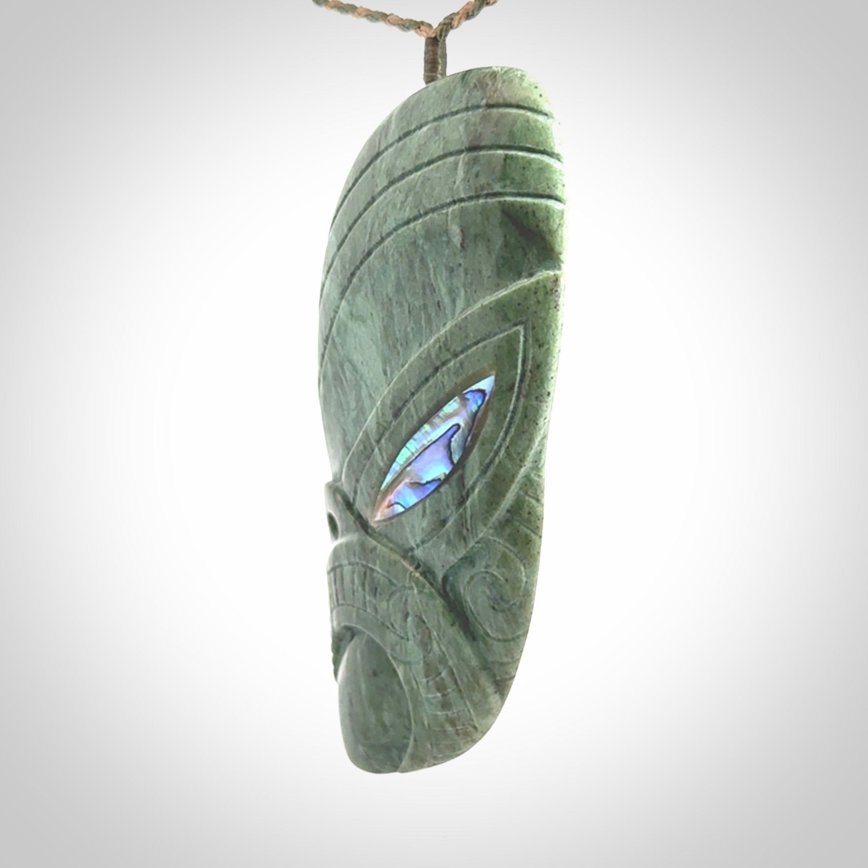 This is a hand carved New Zealand Jade wheku pendant. It is made from New Zealand Jade and Paua shell.
