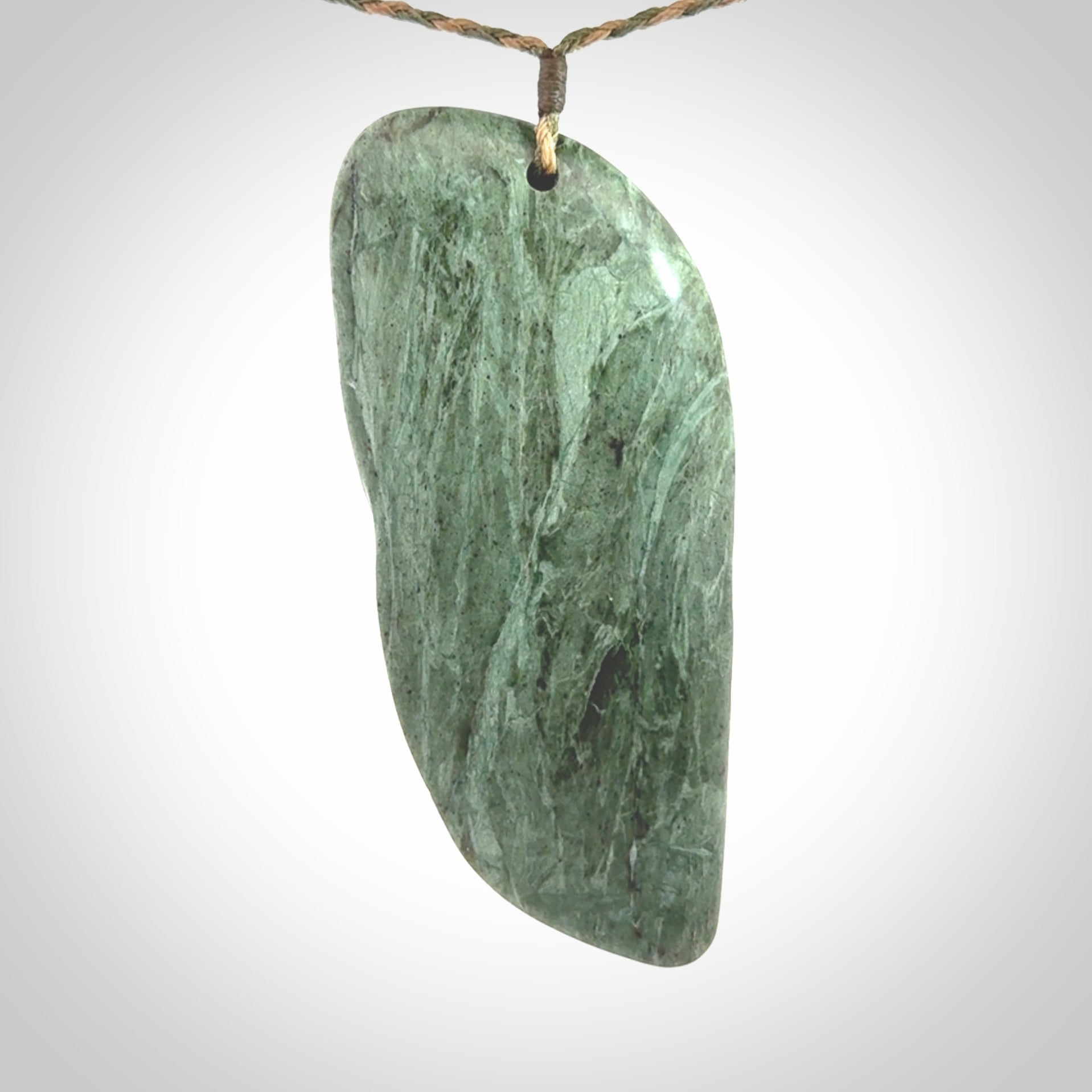 This is a hand carved New Zealand Jade wheku pendant. It is made from New Zealand Jade and Paua shell.