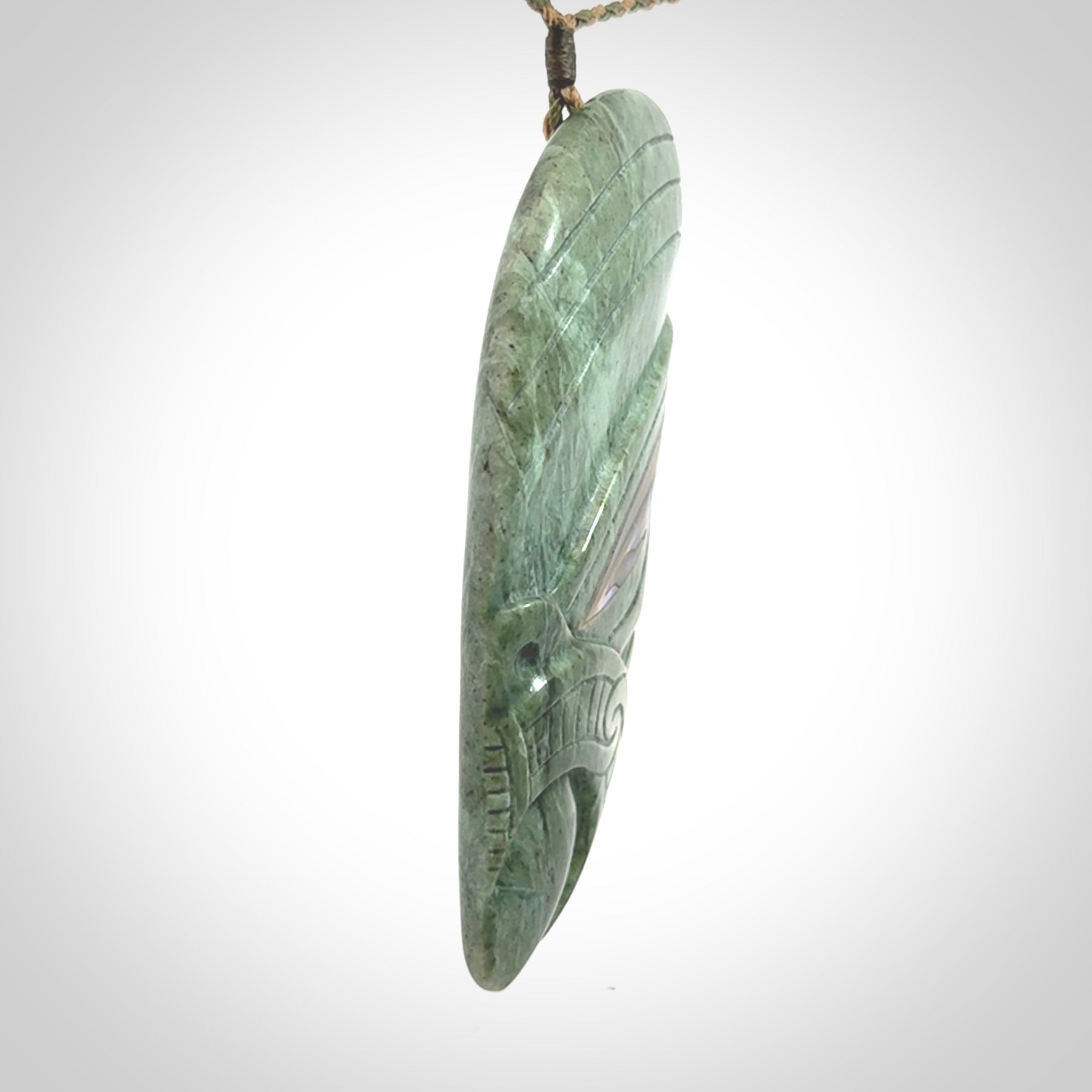 This is a hand carved New Zealand Jade wheku pendant. It is made from New Zealand Jade and Paua shell.