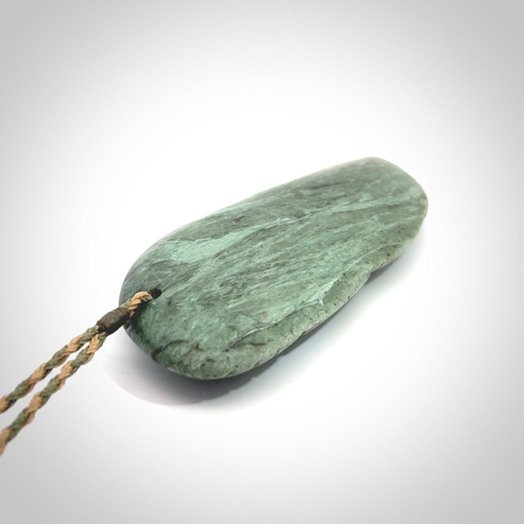 This is a hand carved New Zealand Jade wheku pendant. It is made from New Zealand Jade and Paua shell.