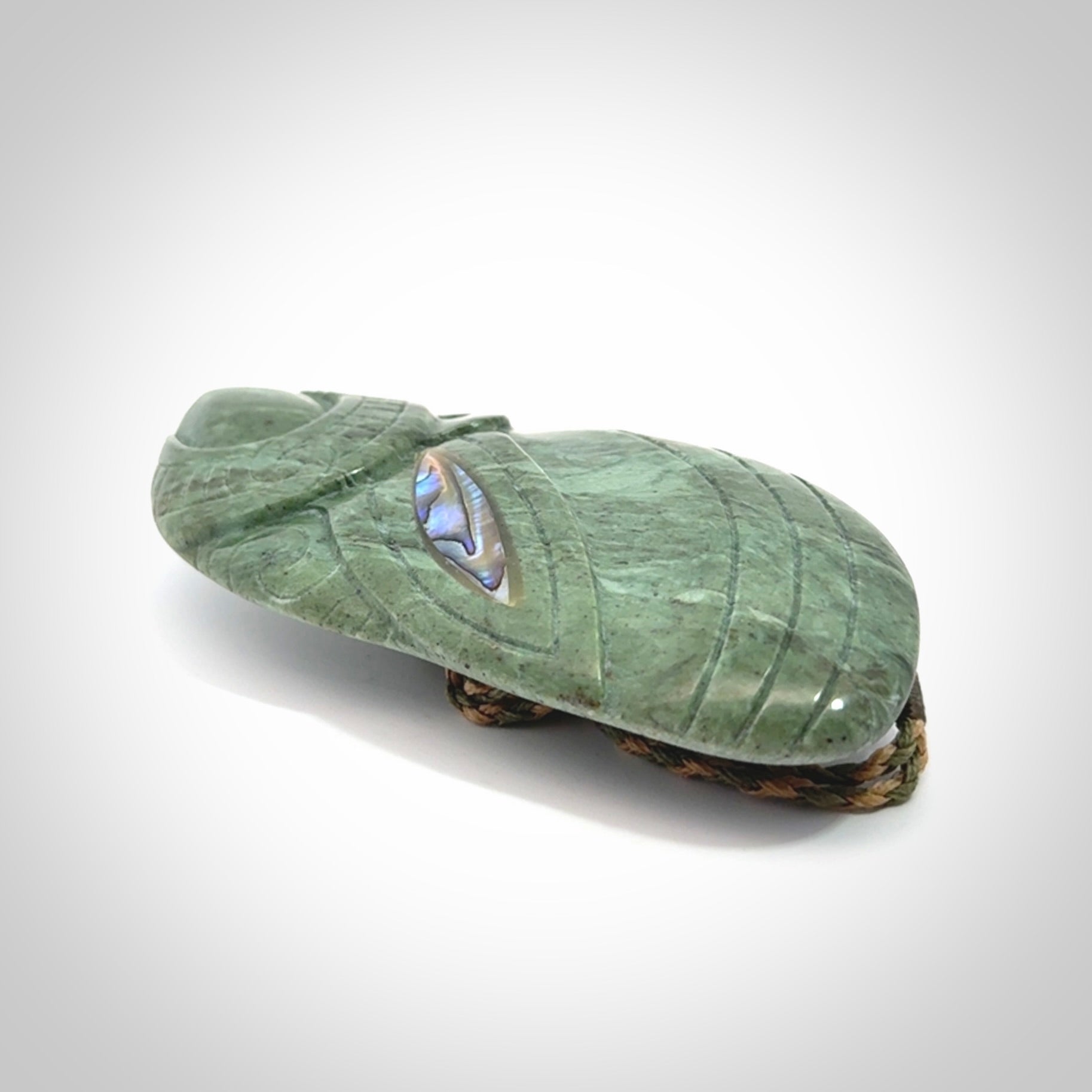 This is a hand carved New Zealand Jade wheku pendant. It is made from New Zealand Jade and Paua shell.
