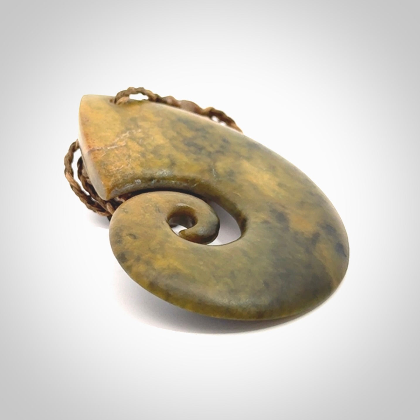 A hand carved koru pendant from New Zealand Flower Jade. The cord is a camel/marrakesh colour and is an adjustable length. A large hand made Koru necklace by New Zealand artist Kerry Thompson.