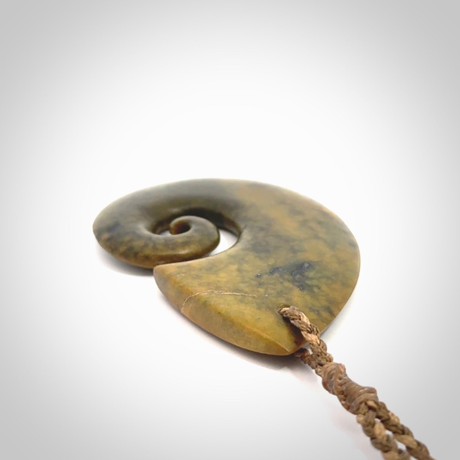 A hand carved koru pendant from New Zealand Flower Jade. The cord is a camel/marrakesh colour and is an adjustable length. A large hand made Koru necklace by New Zealand artist Kerry Thompson.