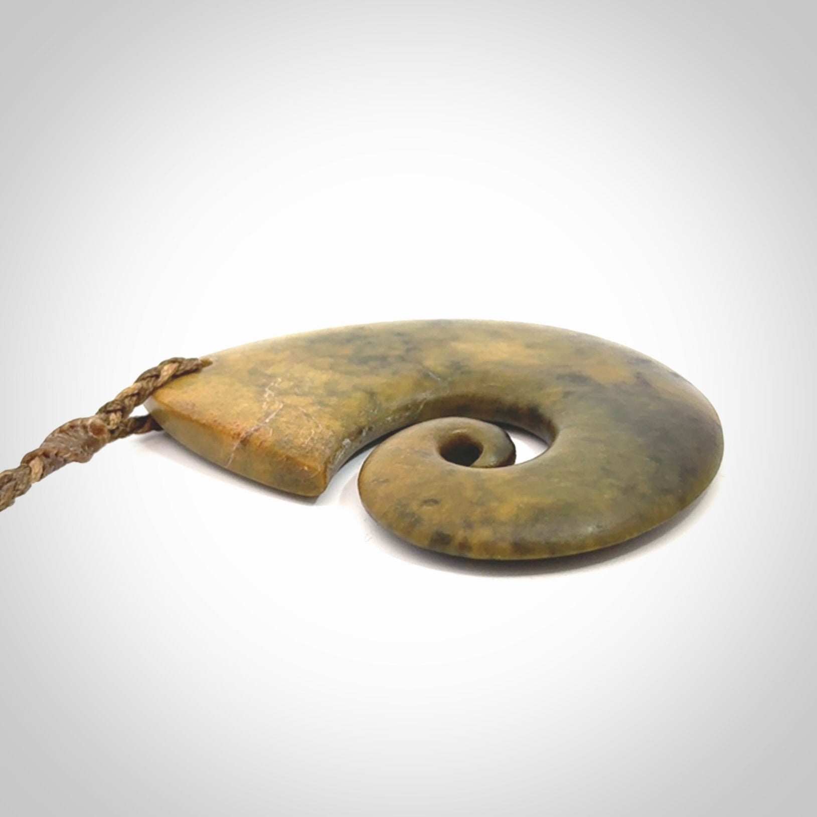 A hand carved koru pendant from New Zealand Flower Jade. The cord is a camel/marrakesh colour and is an adjustable length. A large hand made Koru necklace by New Zealand artist Kerry Thompson.
