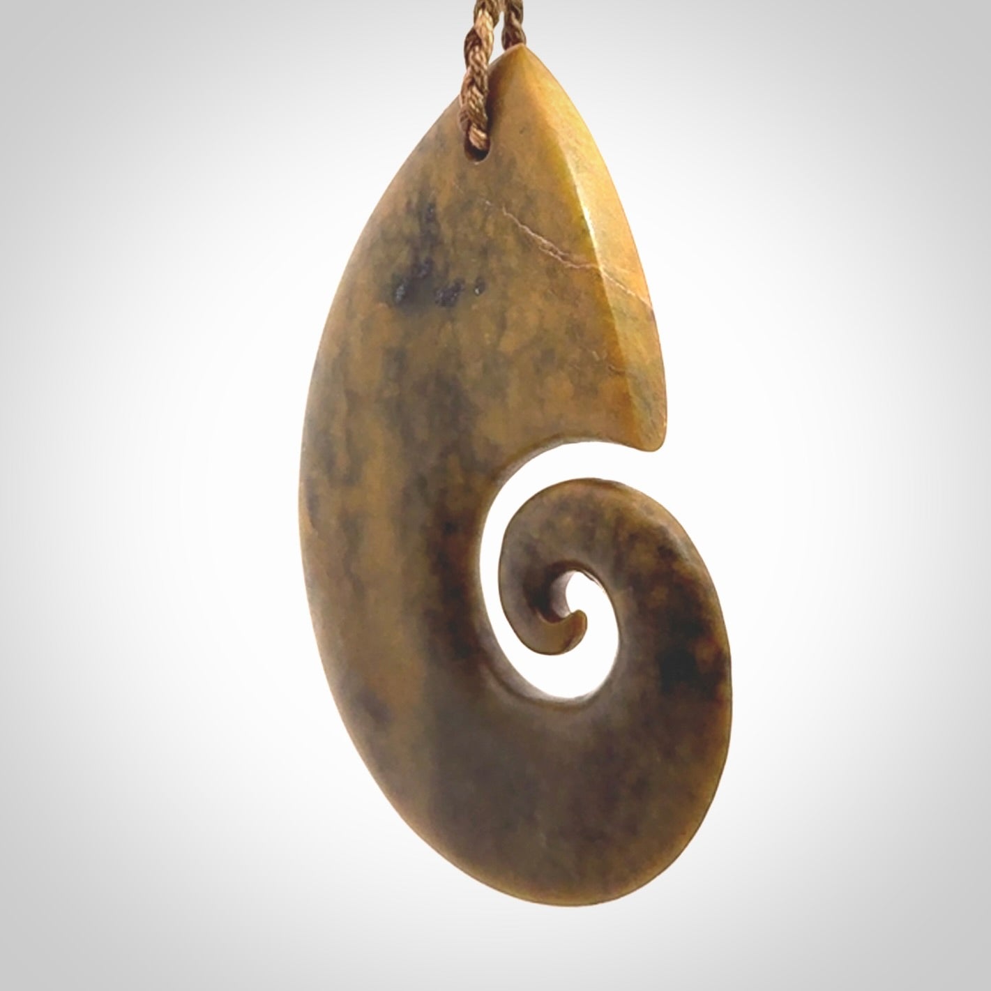 A hand carved koru pendant from New Zealand Flower Jade. The cord is a camel/marrakesh colour and is an adjustable length. A large hand made Koru necklace by New Zealand artist Kerry Thompson.