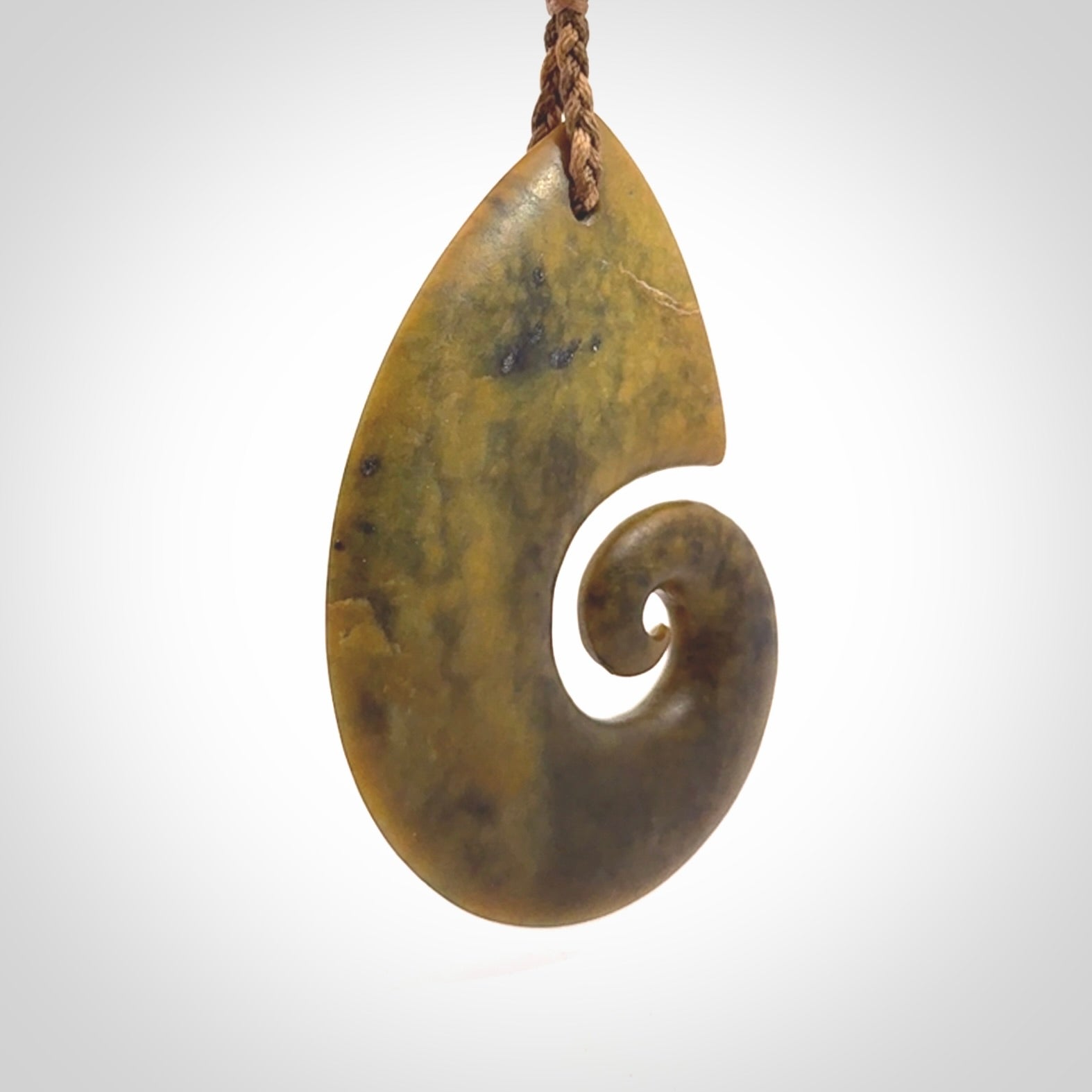 A hand carved koru pendant from New Zealand Flower Jade. The cord is a camel/marrakesh colour and is an adjustable length. A large hand made Koru necklace by New Zealand artist Kerry Thompson.