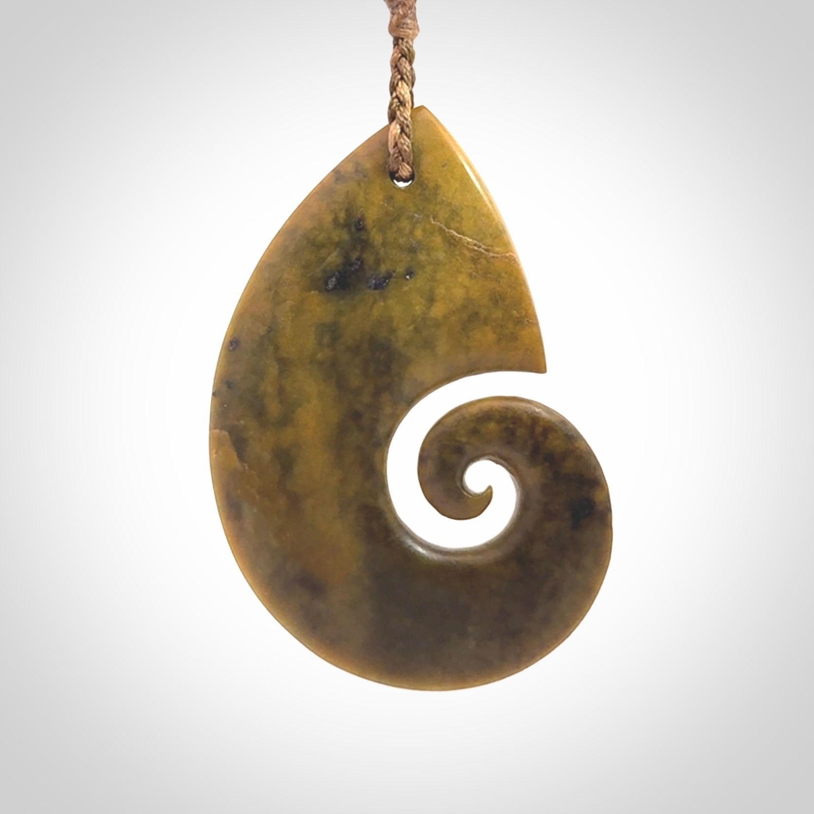 A hand carved koru pendant from New Zealand Flower Jade. The cord is a camel/marrakesh colour and is an adjustable length. A large hand made Koru necklace by New Zealand artist Kerry Thompson.