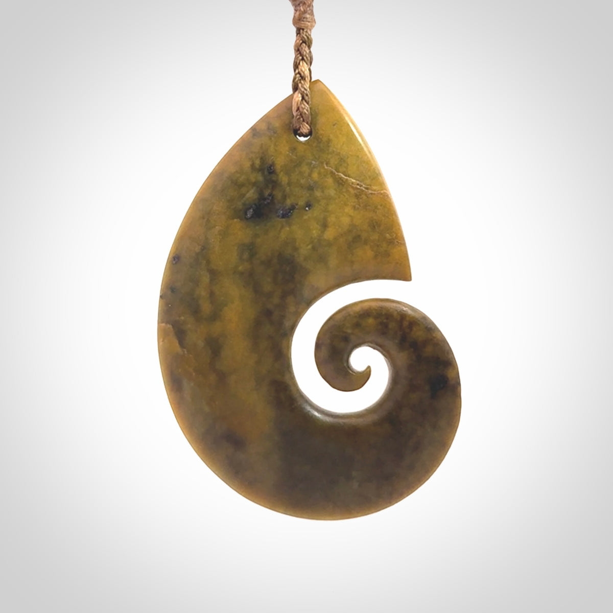 A hand carved koru pendant from New Zealand Flower Jade. The cord is a camel/marrakesh colour and is an adjustable length. A large hand made Koru necklace by New Zealand artist Kerry Thompson.