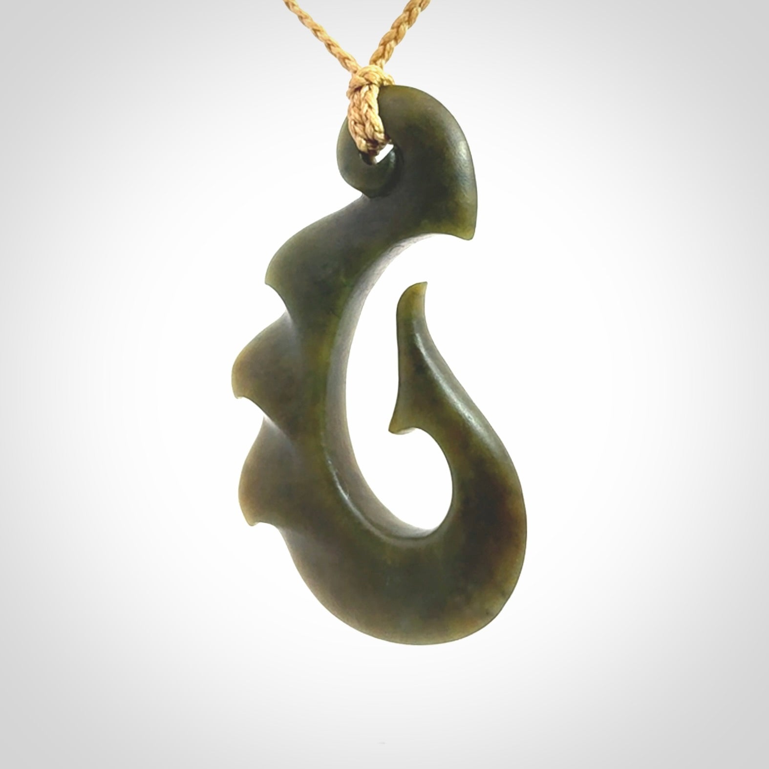 Hand carved New Zealand Totoweka Jade hook pendant.