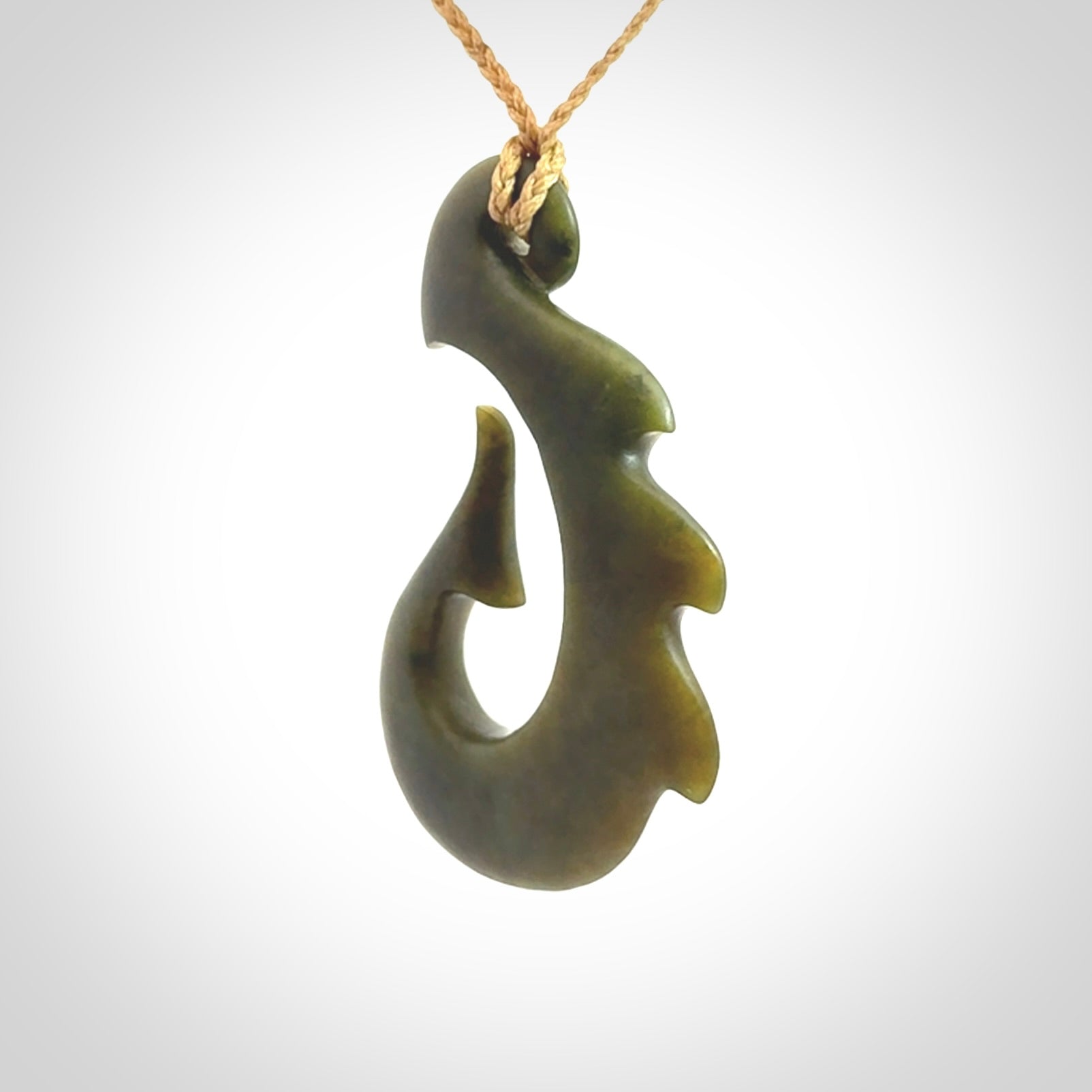 Hand carved New Zealand Totoweka Jade hook pendant.