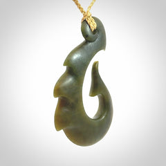 Hand carved New Zealand Totoweka Jade hook pendant.