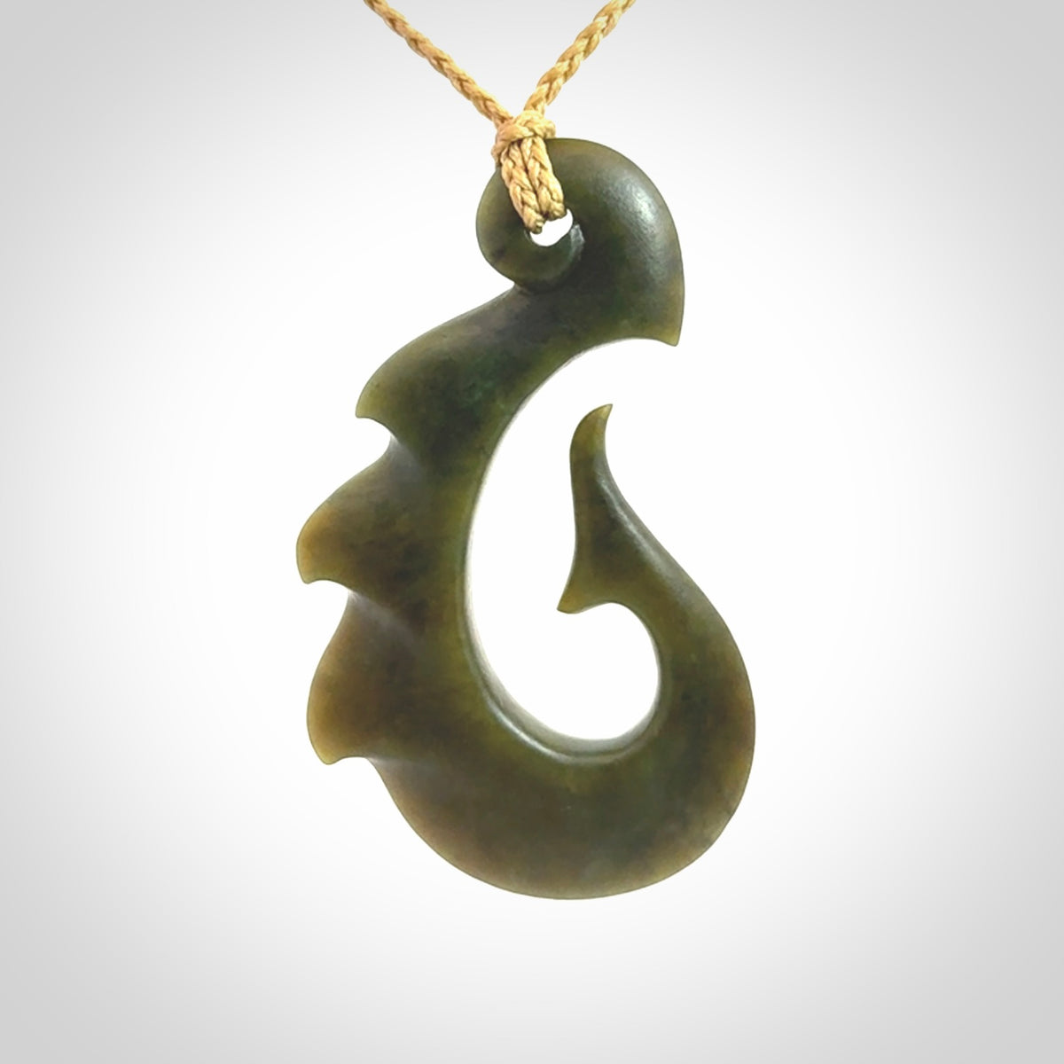 Hand carved New Zealand Totoweka Jade hook pendant.