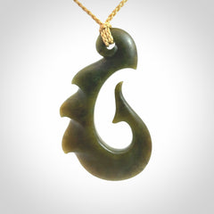 Hand carved New Zealand Totoweka Jade hook pendant.
