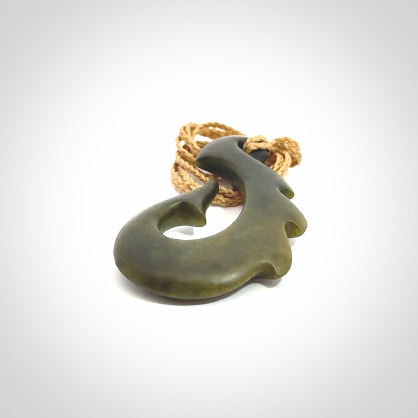 Hand carved New Zealand Totoweka Jade hook pendant.