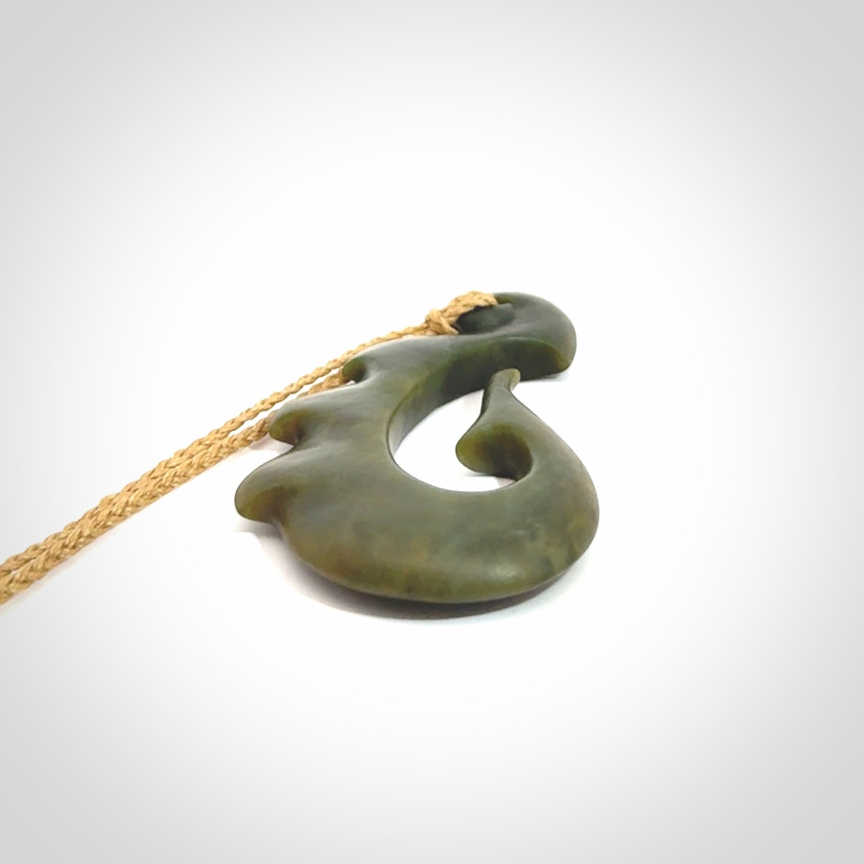 Hand carved New Zealand Totoweka Jade hook pendant.