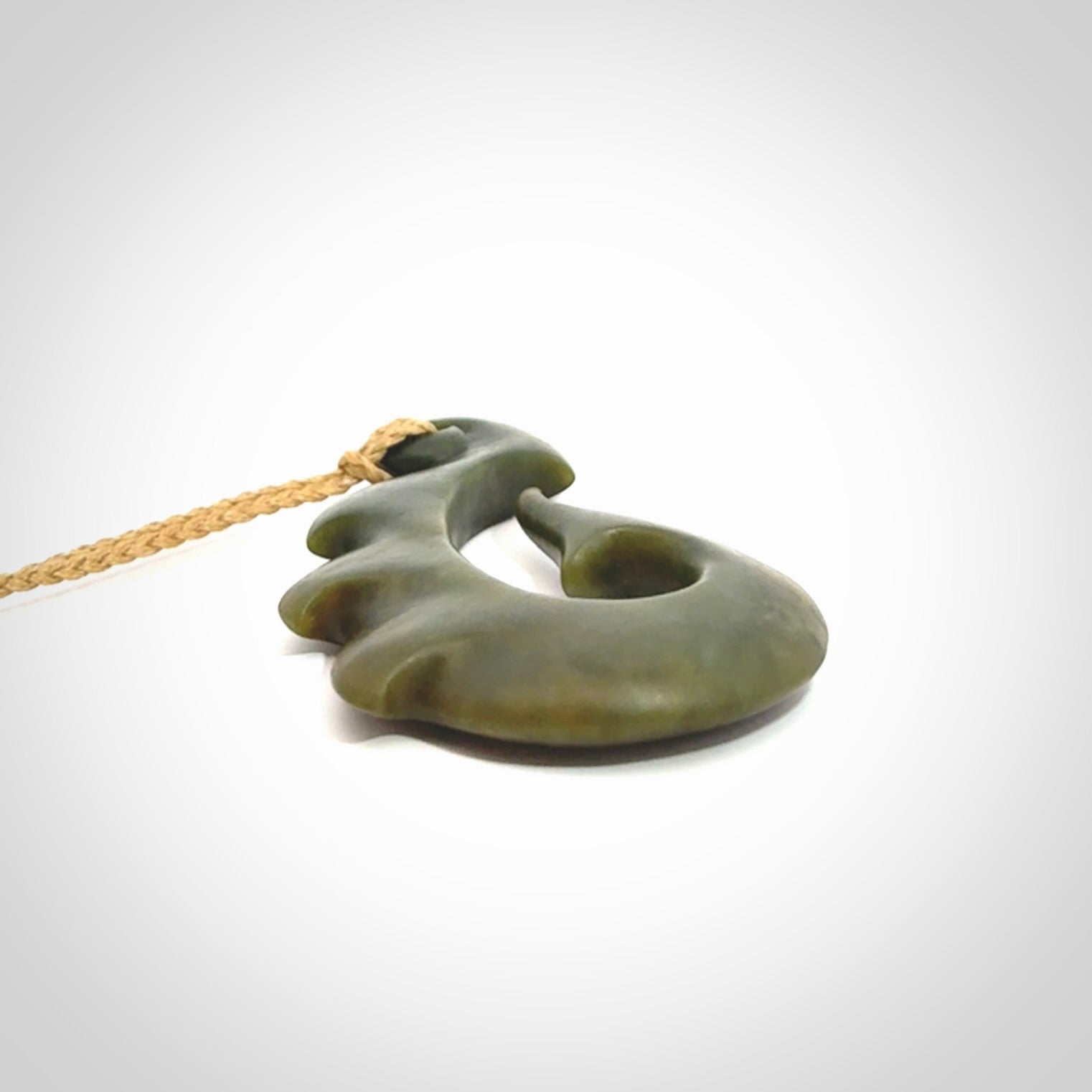 Hand carved New Zealand Totoweka Jade hook pendant.
