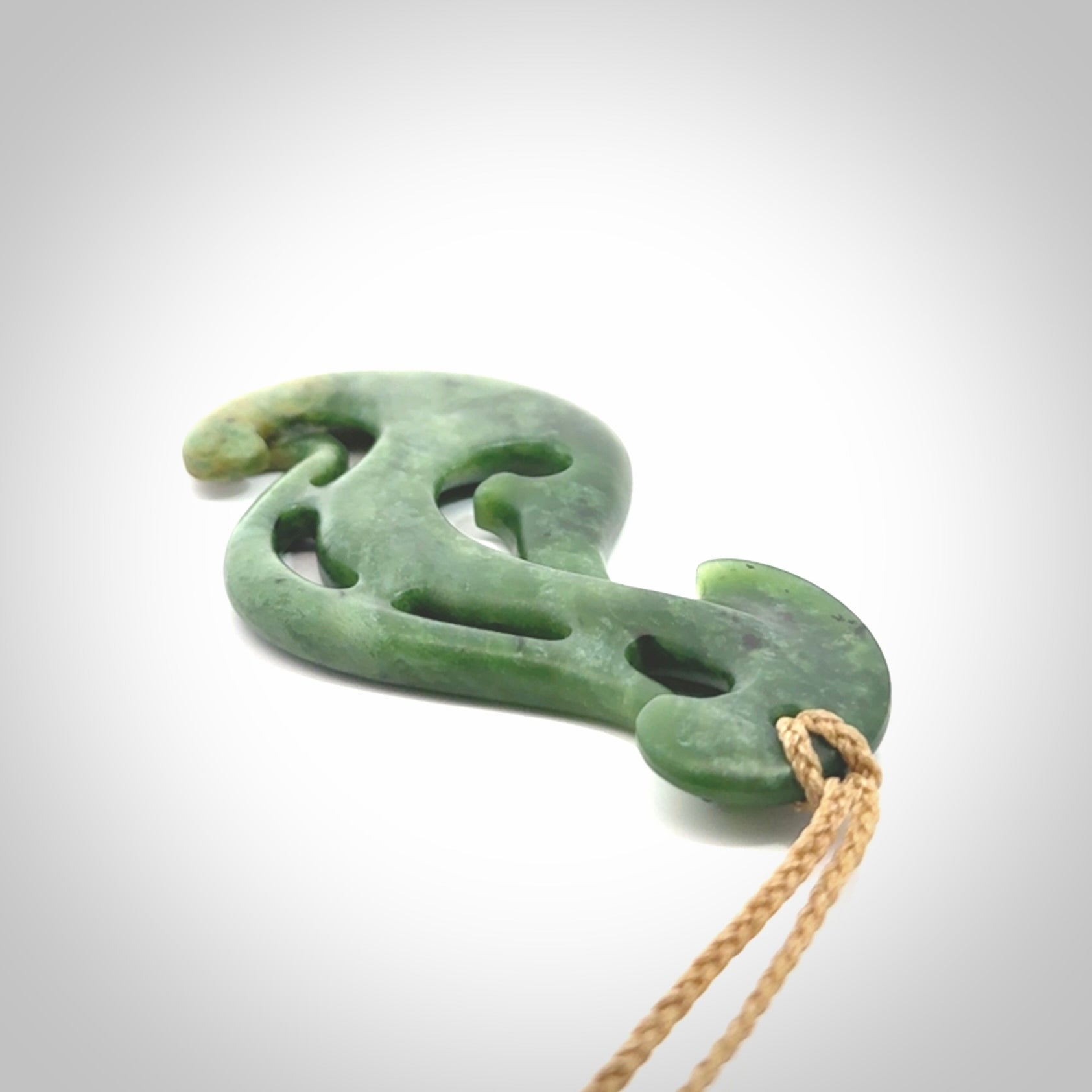 A hand carved large New Zealand Jade Hook, Matau, necklace. The cord is adjustable.