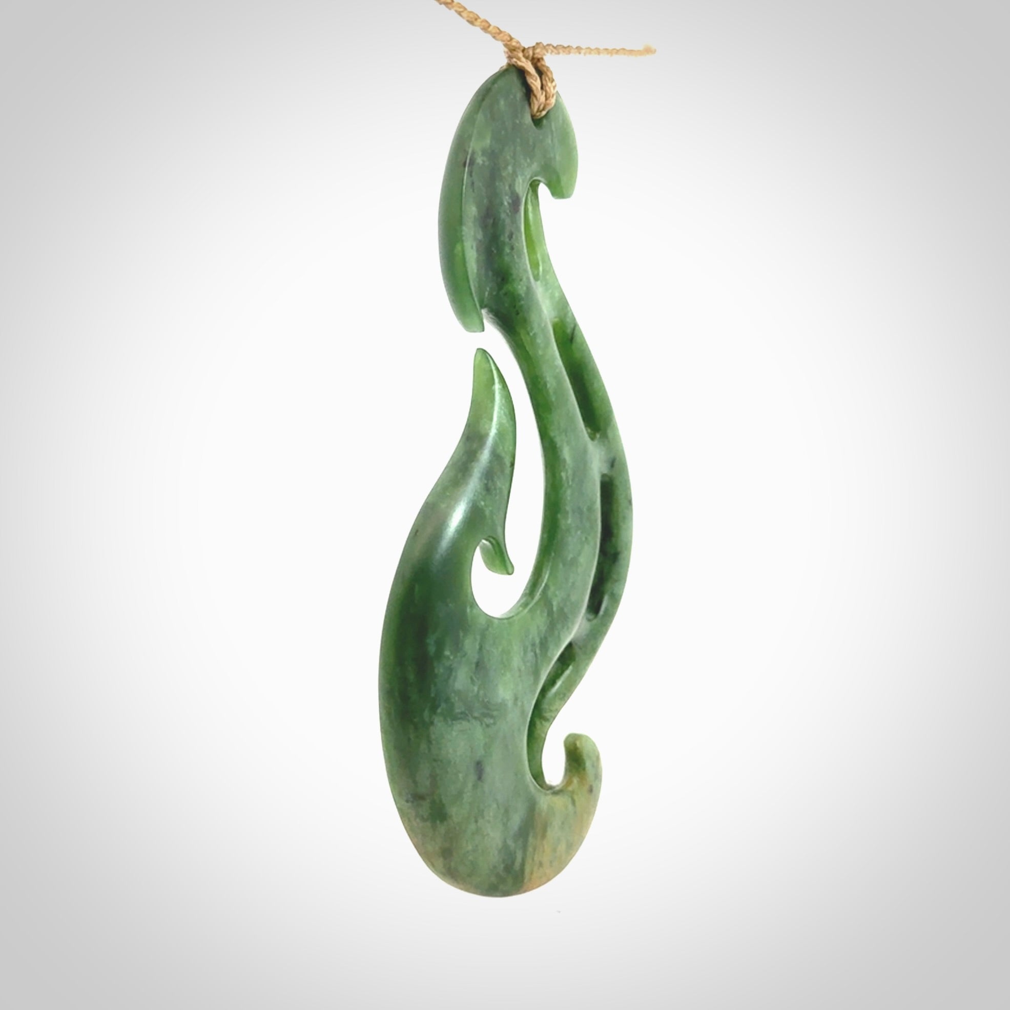 A hand carved large New Zealand Jade Hook, Matau, necklace. The cord is adjustable.