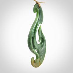 A hand carved large New Zealand Jade Hook, Matau, necklace. The cord is adjustable.