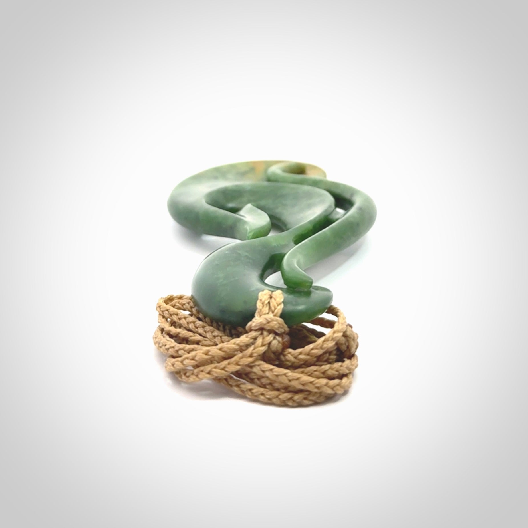 A hand carved large New Zealand Jade Hook, Matau, necklace. The cord is adjustable.