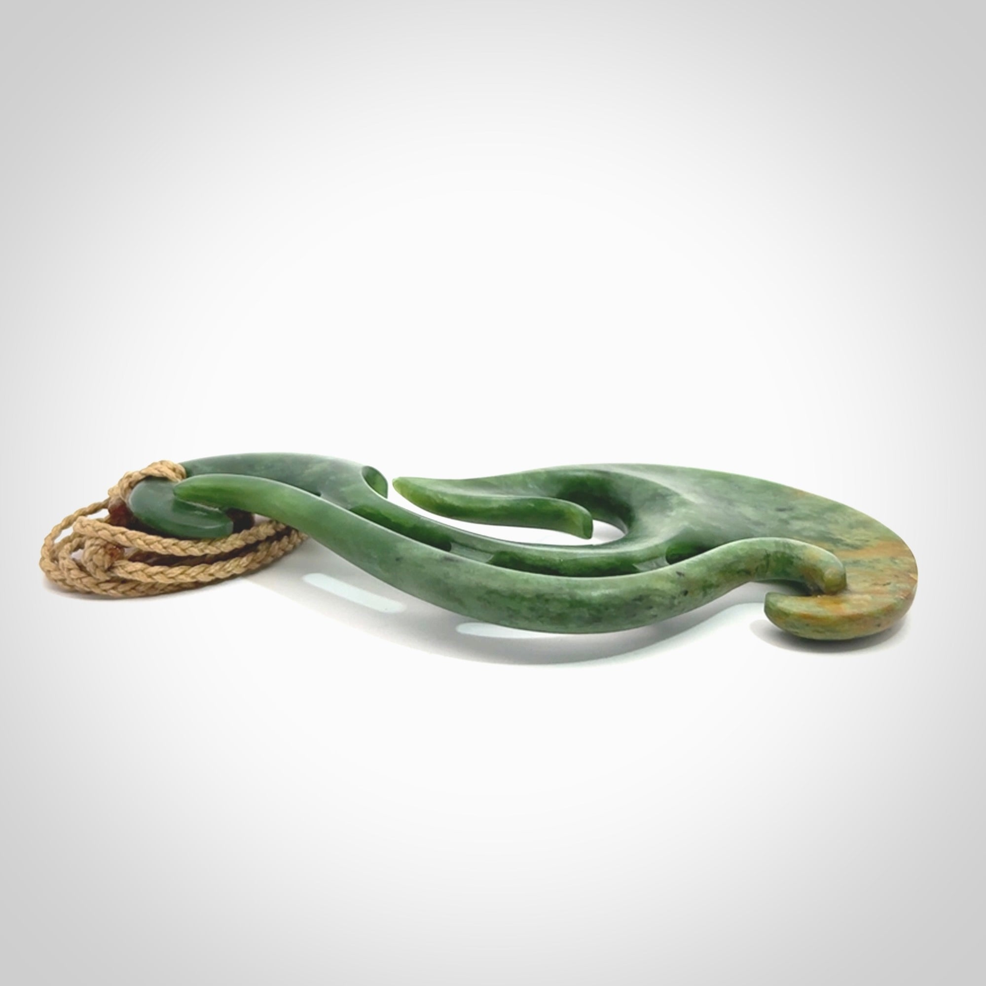 A hand carved large New Zealand Jade Hook, Matau, necklace. The cord is adjustable.