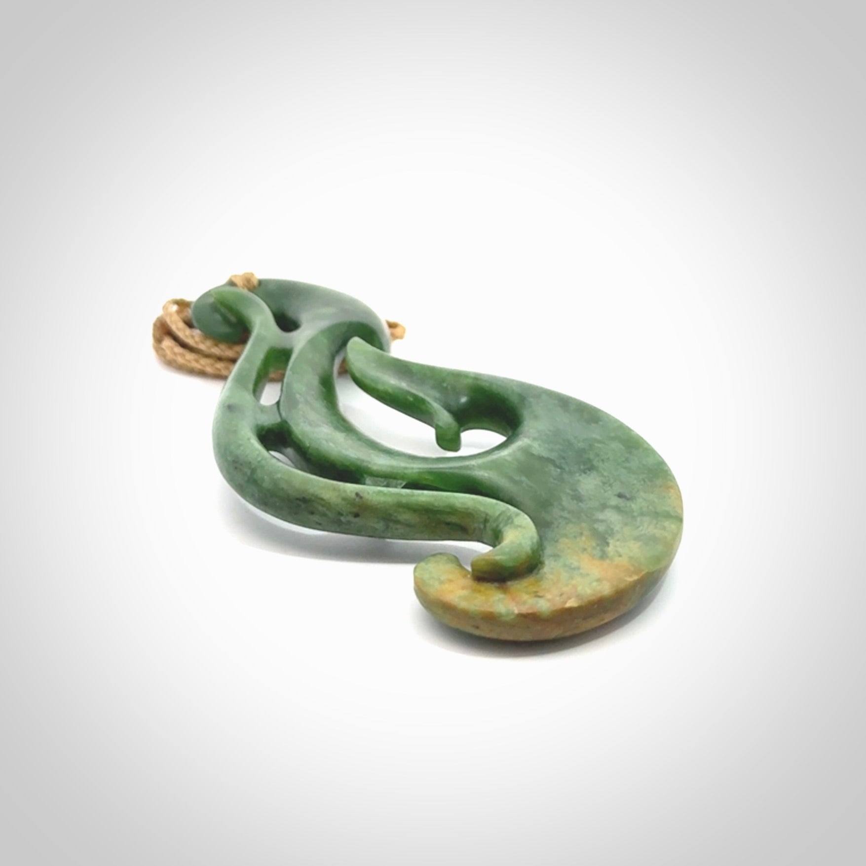 A hand carved large New Zealand Jade Hook, Matau, necklace. The cord is adjustable.
