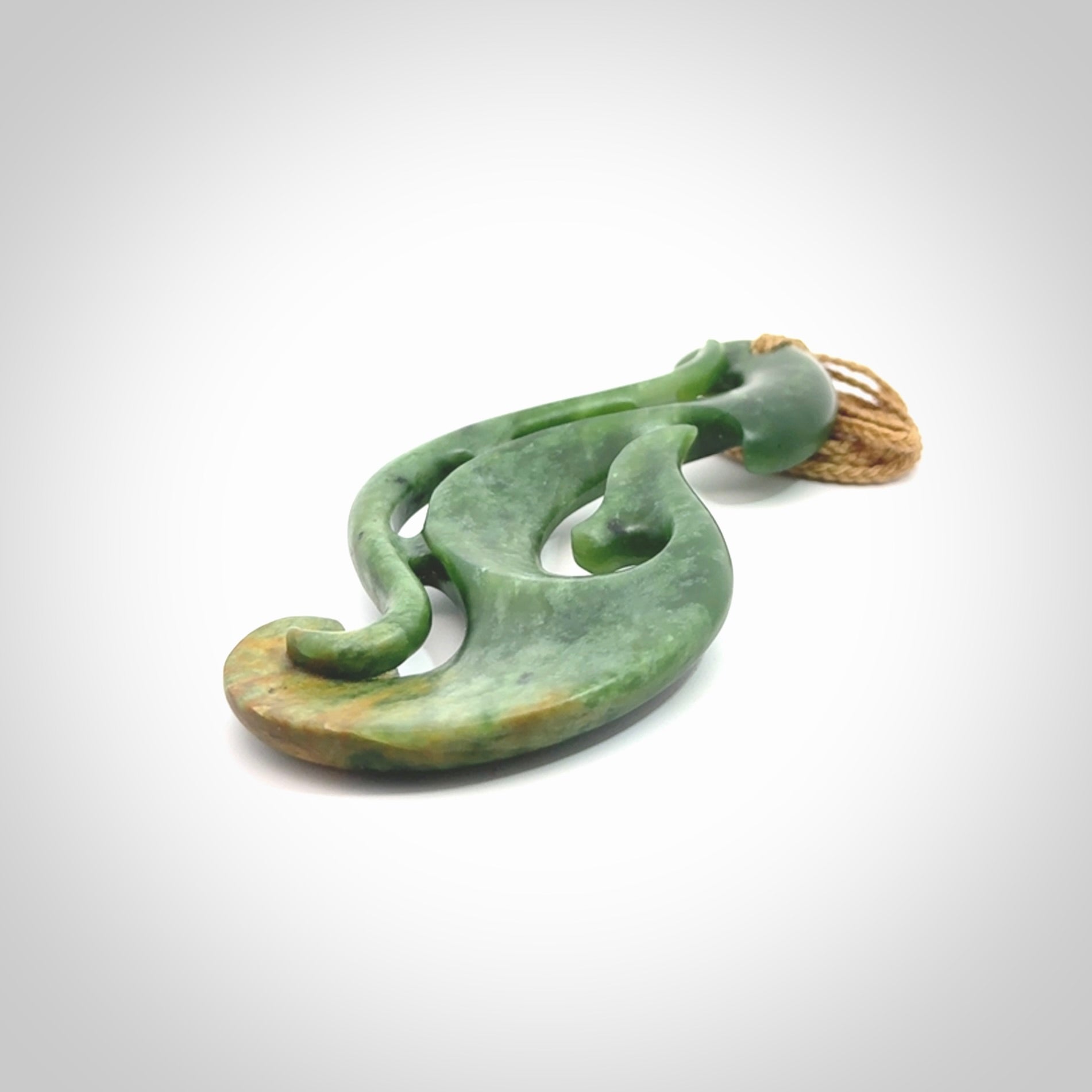 A hand carved large New Zealand Jade Hook, Matau, necklace. The cord is adjustable.