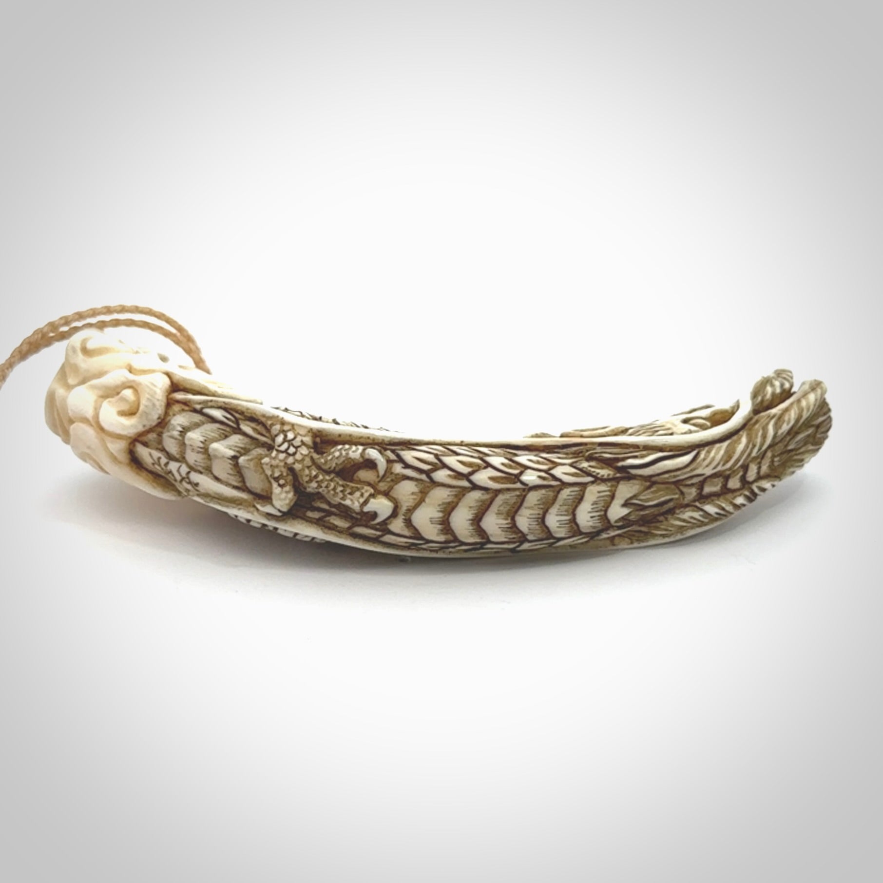 Hand carved dragon Pendant. Made from warthog tusk in New Zealand. Unique dragon necklace hand made from warthog tusk by master bone carver Fumio Noguchi. Spectacular collectable work of art, made to wear. One only pendant, delivered to you at no extra cost with express courier.