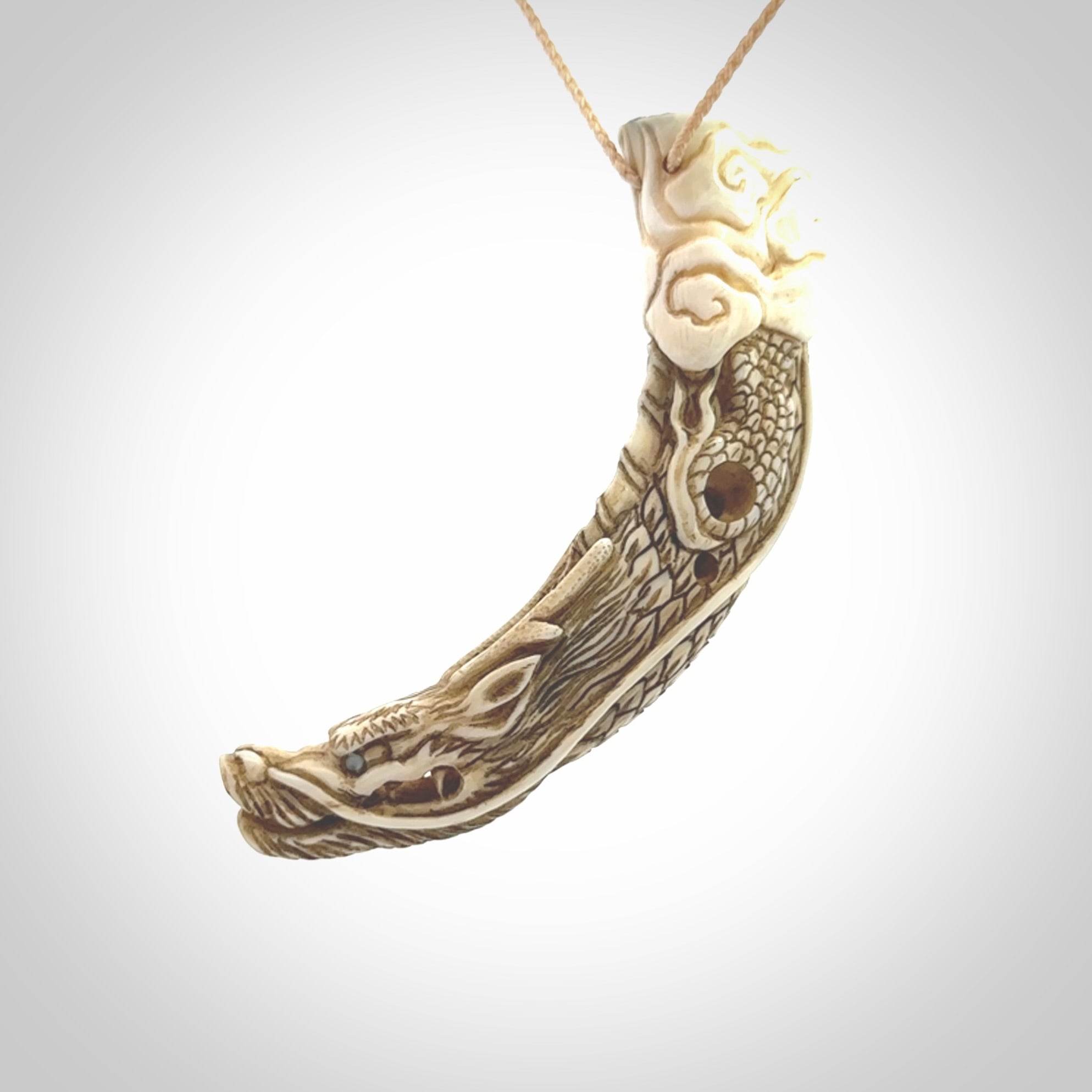 Hand carved dragon Pendant. Made from warthog tusk in New Zealand. Unique dragon necklace hand made from warthog tusk by master bone carver Fumio Noguchi. Spectacular collectable work of art, made to wear. One only pendant, delivered to you at no extra cost with express courier.