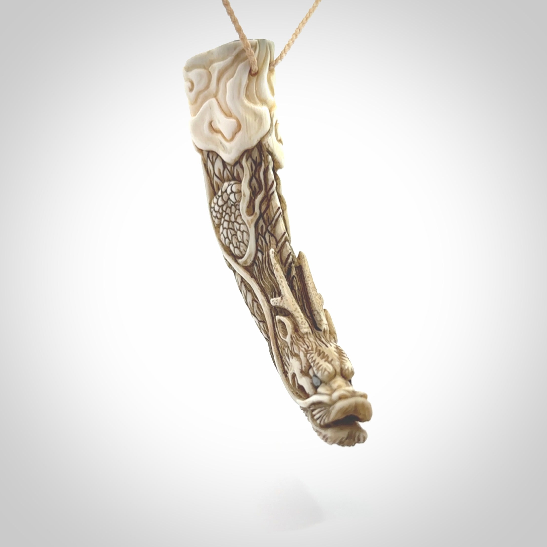 Hand carved dragon Pendant. Made from warthog tusk in New Zealand. Unique dragon necklace hand made from warthog tusk by master bone carver Fumio Noguchi. Spectacular collectable work of art, made to wear. One only pendant, delivered to you at no extra cost with express courier.