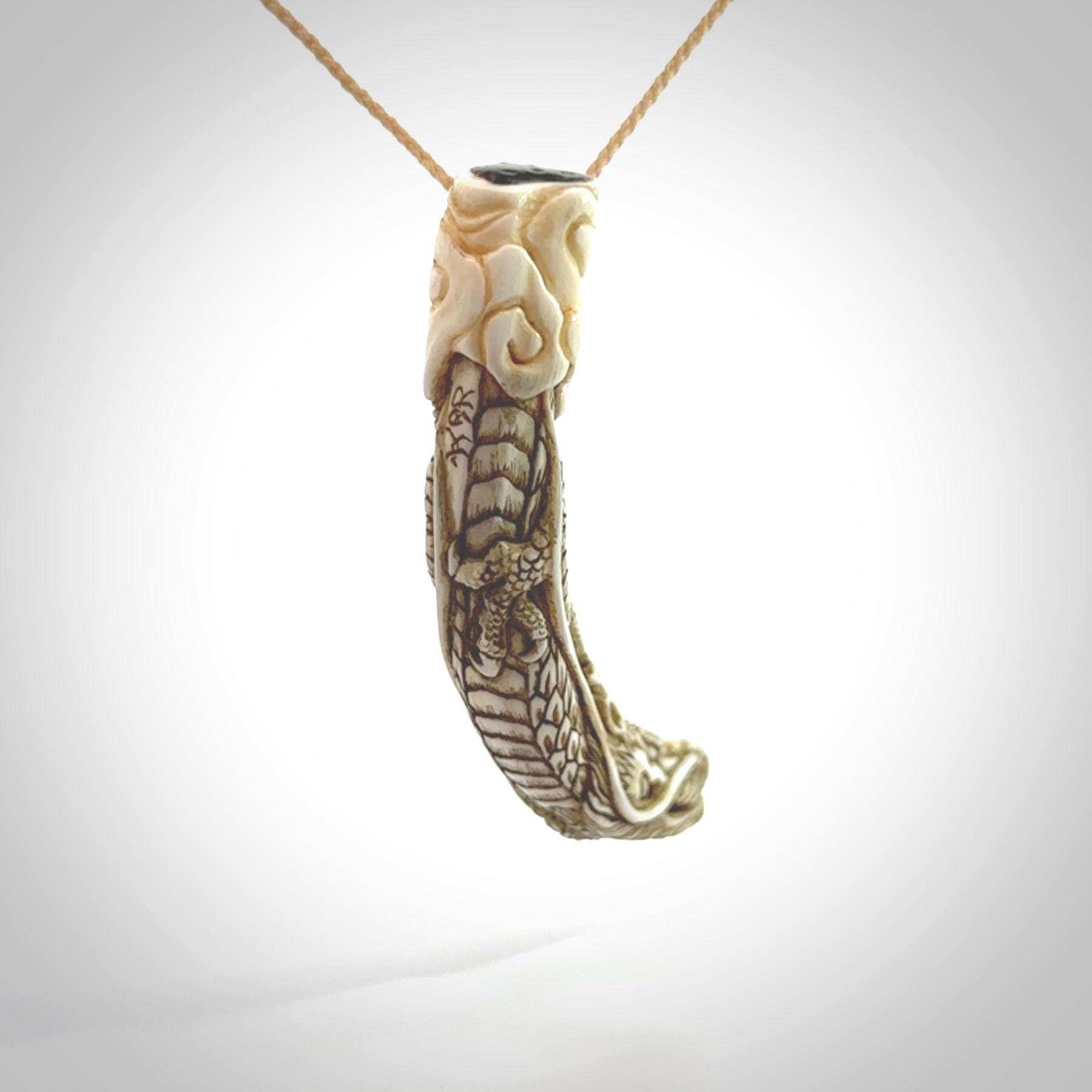 Hand carved dragon Pendant. Made from warthog tusk in New Zealand. Unique dragon necklace hand made from warthog tusk by master bone carver Fumio Noguchi. Spectacular collectable work of art, made to wear. One only pendant, delivered to you at no extra cost with express courier.