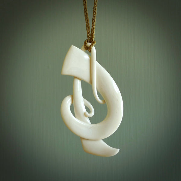 A hand carved bone contemporary, intricate Koru pendant. The cord is tan colour and is an adjustable length. A large sized hand made contemporary necklace by New Zealand artist Kerry Thompson. Kerry has carved this from Beef bone. One off work of art to wear.