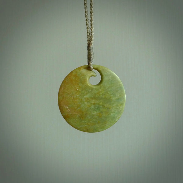 This is a large green New Zealand jade koru pendant. We have bound this with a fine khaki coloured cord necklace. The necklace is adjustable so you can position the piece where it suits you the best. Hand made by Ric Moor.