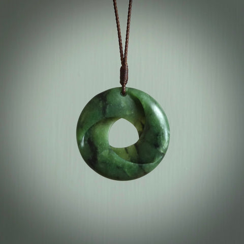 This little piece is a hand carved möbius ribbon pendant. We've carved this from New Zealand Jade. It has very subtle colour variations in the stone and is a delightful, small and artistic piece of jewellery. Hand made by Kyohei Noguchi and delivered to you in a kete pouch.