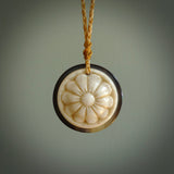 Hand carved natural bone with buffalo horn contemporary disc pendant with creative and unique carvings on the front face of each individual piece. Delivered with an adjustable cord.