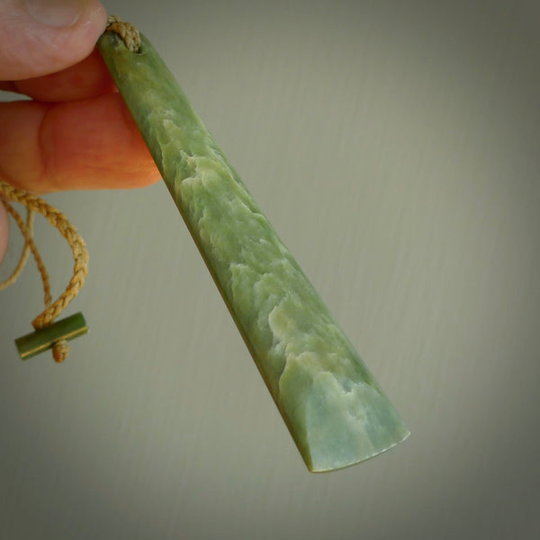 A hand carved large New Zealand Flower Jade drop, roimata, necklace. The cord is a tan colour and is adjustable. A large sized hand made drop necklace by New Zealand artist Kerry Thompson. One off work of art to wear.