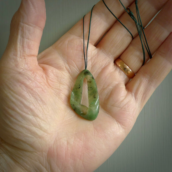 This little piece is a hand carved möbius ribbon pendant. We've carved this from Nephrite Jade from Aceh. It has very subtle colour variations in the stone and is a delightful, small and artistic piece of jewellery.