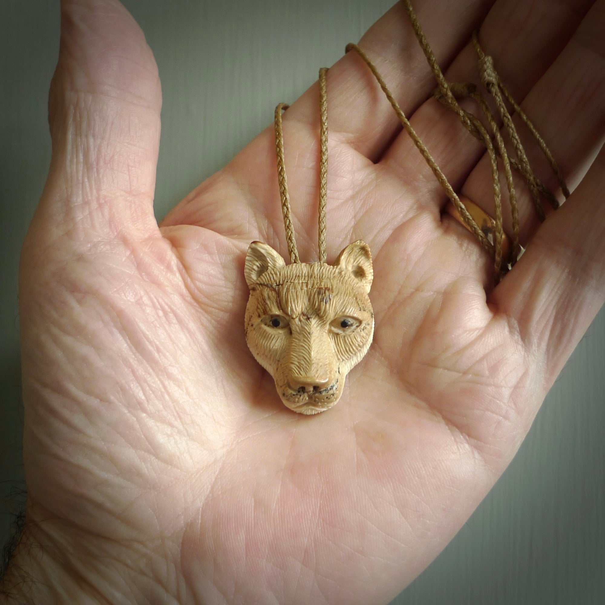 This pendant is a hand carved puma. We've carved this from a lovely piece of woolly mammoth tusk and we provide it with a hand plaited cord. Shipping is free worldwide.