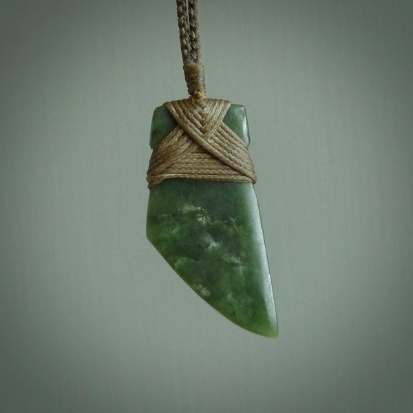 Hand carved from a lovely piece of local New Zealand Jade. The quality of the workmanship and design is outstanding - this is a piece you will want to wear all the time. We have suspended this from a 4-plait olive cord which can be adjusted with a couple of slip knots and olive binding.