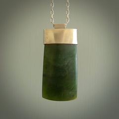 This picture shows a hand carved jade toki, drop pendant with sterling silver cap and chain. The jade is a very dark green with a shimmer in the stone. It is suspended from a sterling silver clasp and we supply a sterling silver chain. Delivery is free worldwide.
