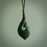 This picture shows a large deep green large jade hook pendant, also called a hei-matau, carved for us in New Zealand jade. The carver is Donna Summers - and this is a beautiful example of his work. The cord is a four-plait, adjustable black coloured necklace.