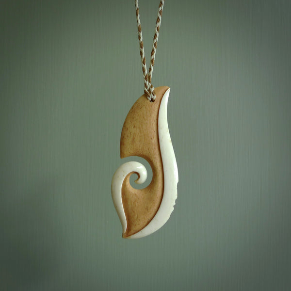 A hand carved bone contemporary, intricate pendant. The cord is a 4 strand, 3 plait in Ice White and Tan and is an adjustable length. A large sized hand made contemporary necklace by New Zealand artist Kerry Thompson. Kerry has stained parts of the bone which really add to the dimension of this pendant. One of work of art to wear.
