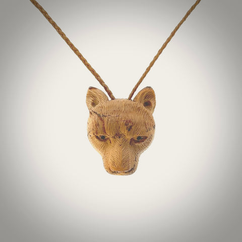 This pendant is a hand carved puma. We've carved this from a lovely piece of woolly mammoth tusk and we provide it with a hand plaited cord. Shipping is free worldwide.