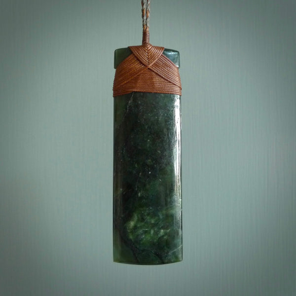 This is a lovely, one-off large, green toki pendant we've made from a gorgeous New Zealand jade. It is finished in a polished sheen and is bound with our plaited cord. These are wonderful pieces that are very attractive and will last a lifetime.