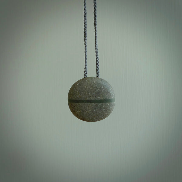 A drop pendant made from Onewa Stone - New Zealand Greywacke - with a fine Pounamu insert spliced into the middle.