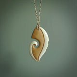 A hand carved bone contemporary, intricate pendant. The cord is ice white/gingernut and is an adjustable length. A large sized hand made contemporary necklace by New Zealand artist Kerry Thompson. Kerry has stained parts of the bone which really add to the dimension of this pendant. One off work of art to wear.