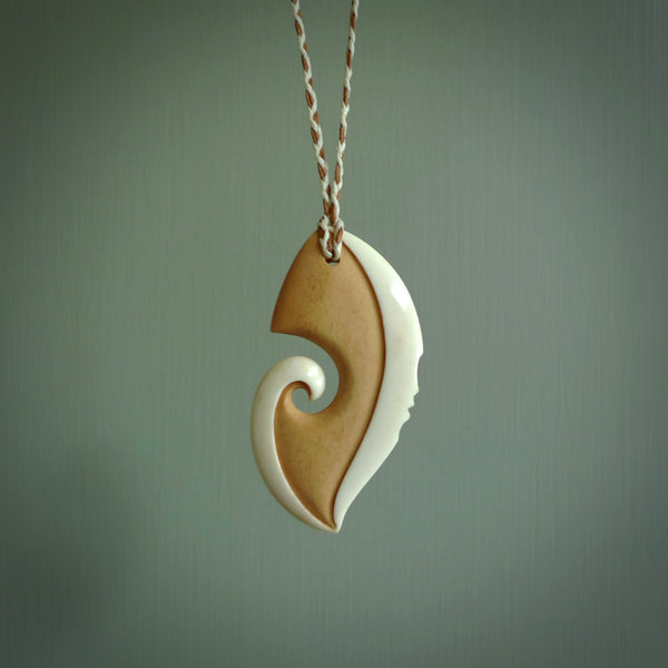 A hand carved bone contemporary, intricate pendant. The cord is ice white/gingernut and is an adjustable length. A large sized hand made contemporary necklace by New Zealand artist Kerry Thompson. Kerry has stained parts of the bone which really add to the dimension of this pendant. One off work of art to wear.