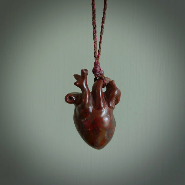 This pendant is handcrafted from Red Jasper Stone. It replicates a human heart. It is supplied with an adjustable burgundy/brown cord. It is a graceful and very interesting piece that will attract admiration and comment. Free Express Shipping.