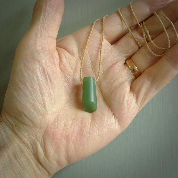 This picture shows a small hand carved jade drop pendant by Ric Moor. The jade is a wonderful light, semi-translucent, green. It is suspended from a beige adjustable cord. Delivery is free worldwide.