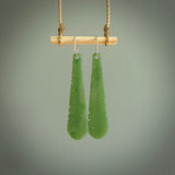 This picture shows New Zealand Pounamu, jade feather earrings with sterling silver hooks. Hand made unique and contemporary feather earrings by Kerry Thompson. Hand carved here in New Zealand from New Zealand Jade. One pair only.